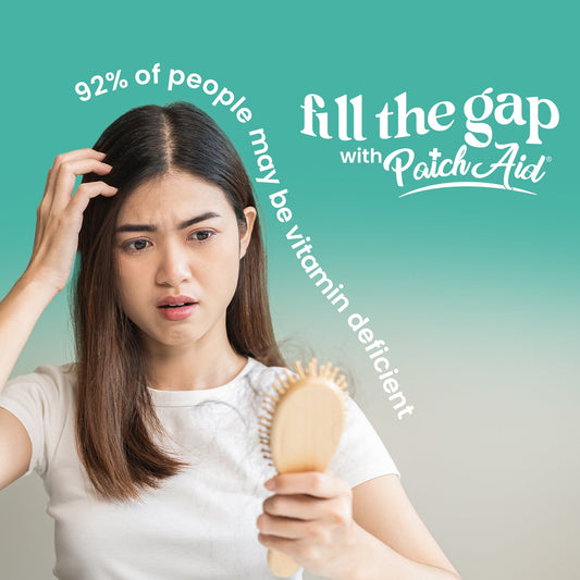 A concerned young woman examines a hairbrush with hair strands while looking worried, against a gradient background with text about vitamin deficiency.