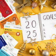A notebook with "2025" and a list titled "GOALS" sits on a golden background surrounded by vitamin patch packages and festive decorations like stars and ornaments.