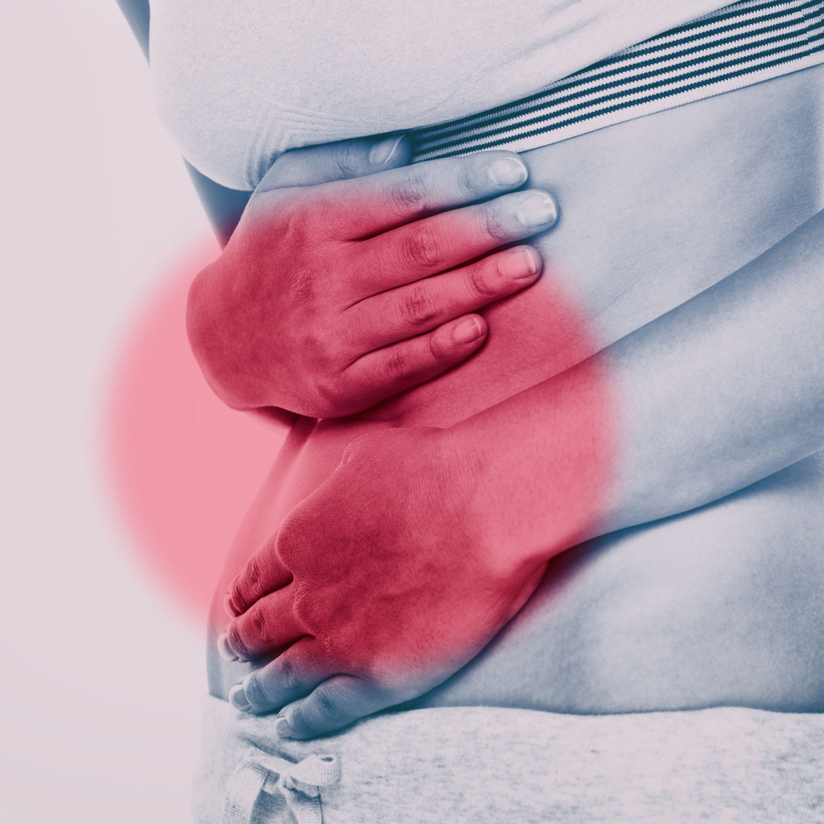 A person holds their stomach with both hands, showing discomfort, against a soft gradient background, emphasizing relief for those suffering from digestive issues.