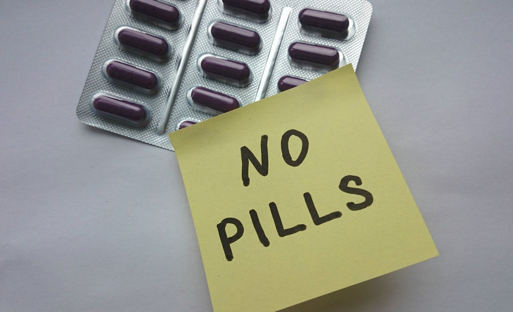 A pack of purple capsules is shown alongside a yellow sticky note that reads