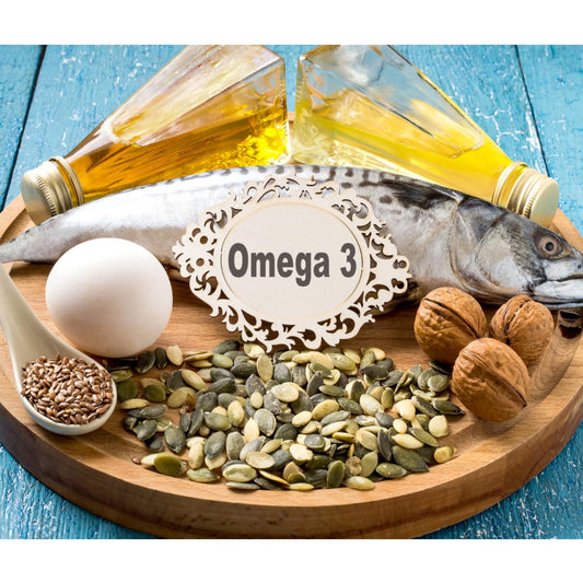 A wooden platter displays a whole fish, an egg, walnuts, pumpkin seeds, flaxseeds, and two bottles of oil, with a decorative label reading "Omega 3" prominently featured.