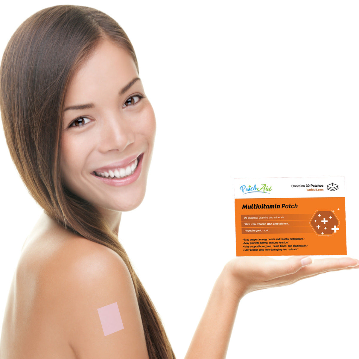 A smiling woman holds a box of multivitamin patches in one hand while showing a patch applied to her shoulder, highlighting a modern approach to vitamin intake.