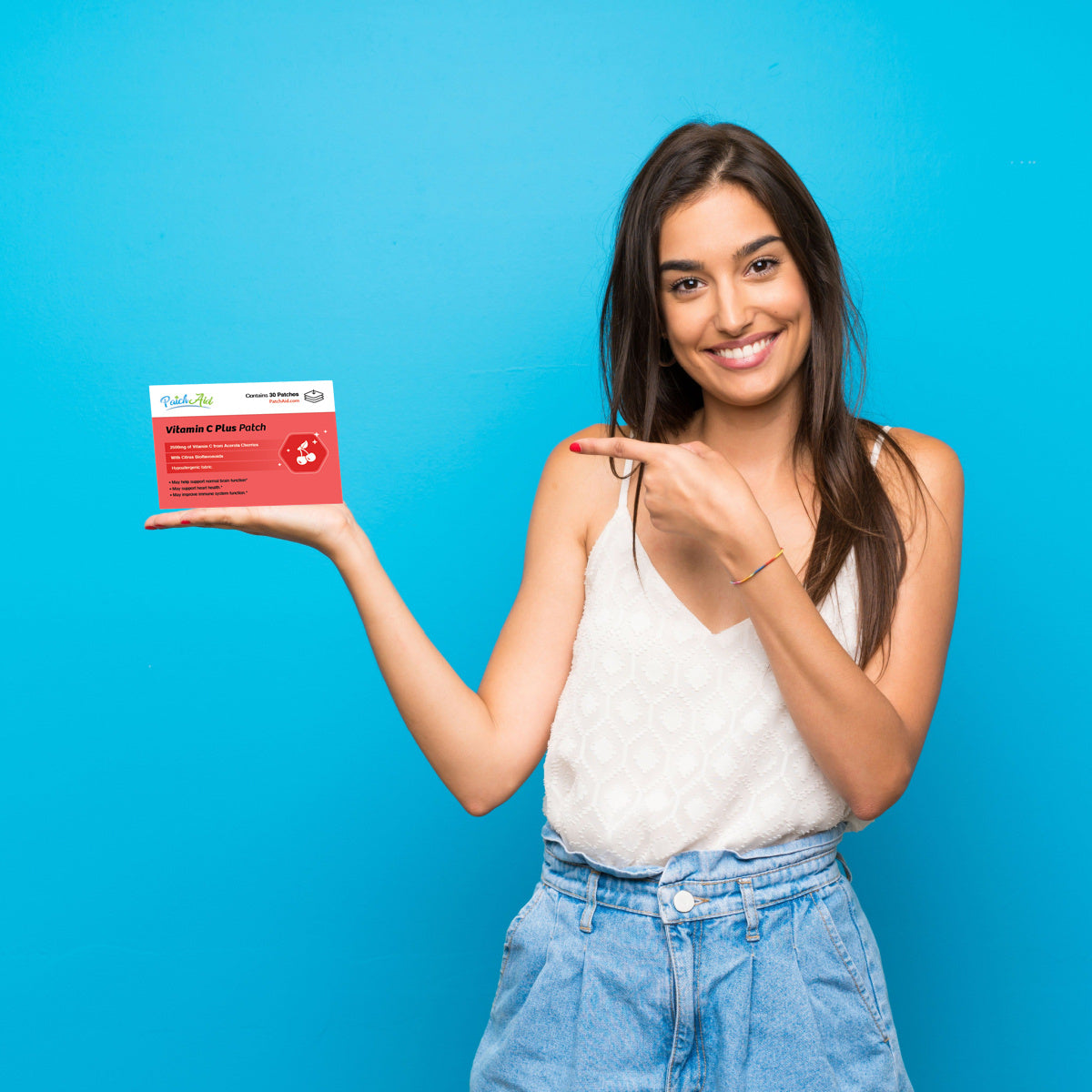 A smiling woman in a white top and blue jeans points to a red box labeled
