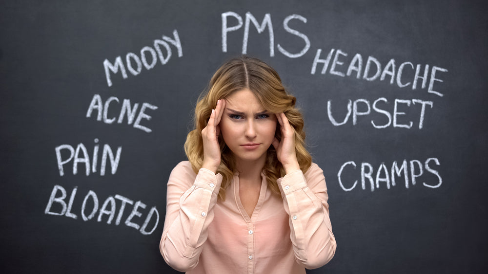 A woman with wavy hair presses her temples in frustration, surrounded by words like