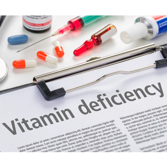 A clipboard with the bold text "Vitamin deficiency" is surrounded by various vitamins, syringes, and a magnifying mirror, suggesting a focus on health and nutritional needs.