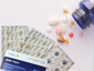 PatchAid NAD+ vitamin patches next to various pills and capsules spilling from a blue bottle, illustrating an alternative to traditional supplements.
