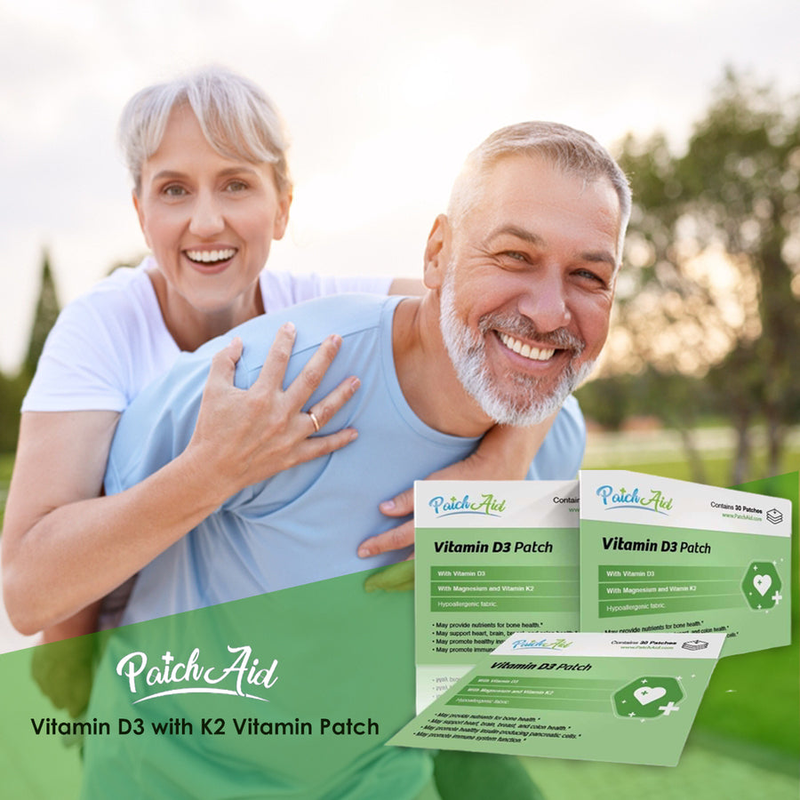 A smiling older couple enjoys a playful moment outdoors, with the woman playfully hugging the man from behind, while PatchAid Vitamin D3 with K2 patches are displayed in the foreground.