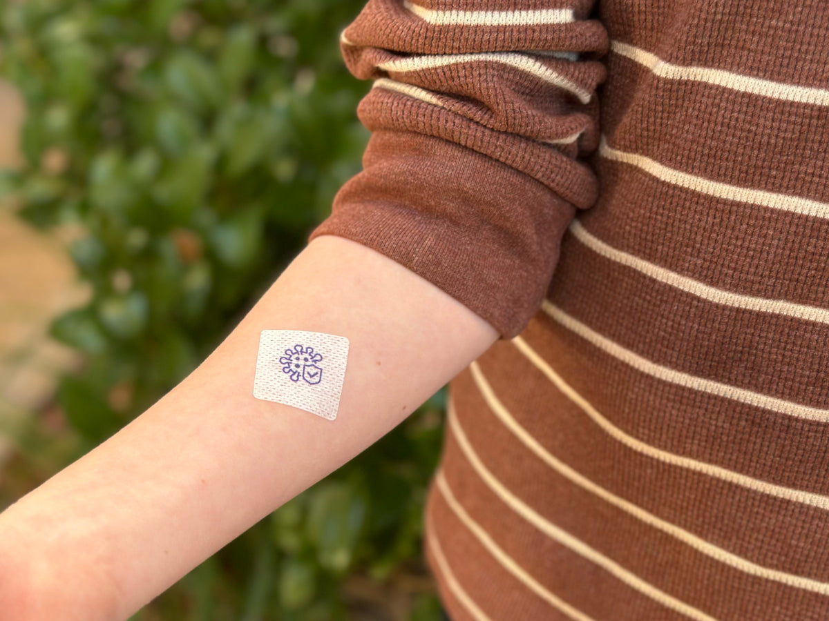 Child smiling outdoors in spring wearing a kids allergy support patch