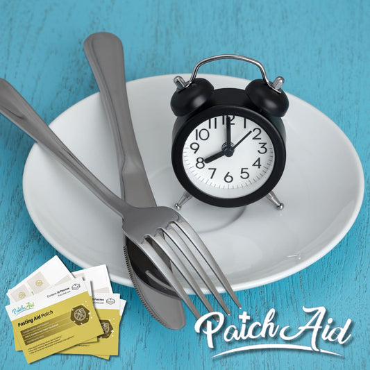 A black alarm clock sits on a white plate with a fork and knife beside it, alongside packages of a fasting aid patch, set against a teal background, symbolizing support for fasting.
