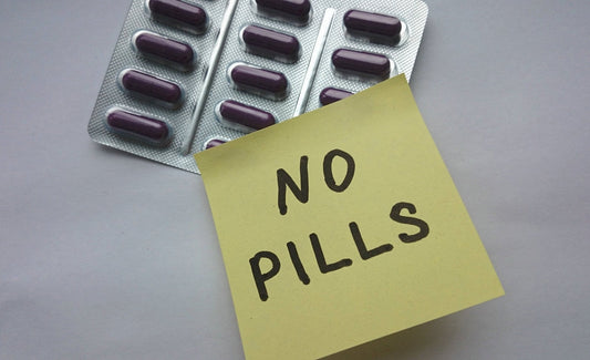 A pack of purple capsules is shown alongside a yellow sticky note that reads "NO PILLS," emphasizing an alternative approach to vitamin supplies.