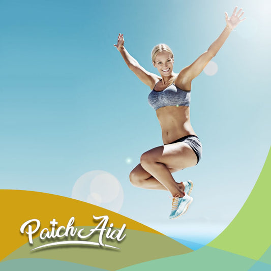 A fit woman in athletic wear jumps joyfully against a bright blue sky, conveying energy and vitality, with the PatchAid logo in the foreground.
