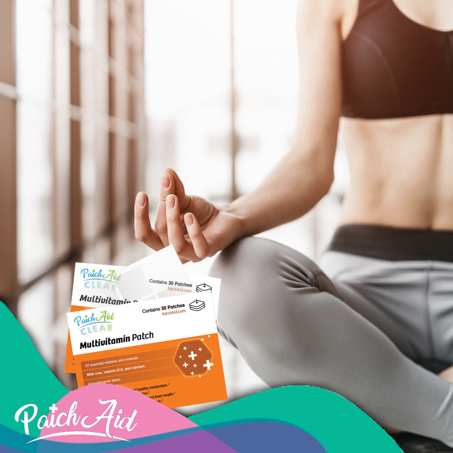 A person in athletic wear sits cross-legged in a bright, modern space, holding a meditative pose while displaying PatchAid multivitamin patches in front of them.